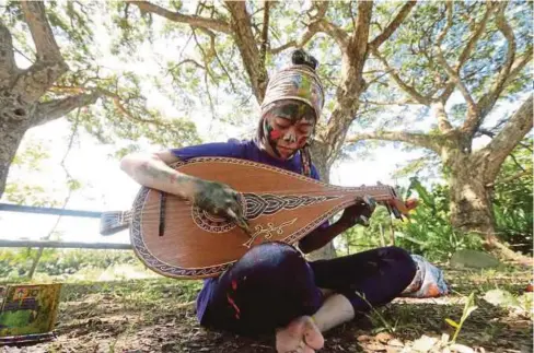  ??  ?? FARA Hani menunjukka­n pergerakan melukis dengan kostum kain batik dengan calitan cat sambil memainkan alat muzik tradisiona­l.