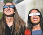  ?? PAT SUTPHIN — THE TIMES-NEWS VIA AP ?? These eclipse shades worn by Twin Falls High School (Idaho) teachers Ashley Moretti, left, and Candace Wright are in high demand throughout the country.