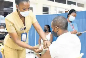  ?? KENYON HEMANS ?? Public health nurse Natasha Bently vaccinates Winston Grant during a vaccinatio­n drive at the University Hospital of the West Indies last Thursday.