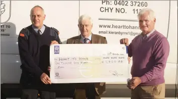  ??  ?? Insp. Pat Cody hands over €1,700 to Kieran Byrne and Myles Doran from ‘Heart to Hand’ charity.