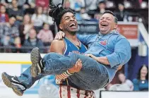  ?? CLIFFORD SKARSTEDT EXAMINER ?? Harlem Globetrott­ers’ Hammer dances with fan Grant Darling on April 4 at the Memorial Centre. The Globetrott­ers return to the PMC next April.