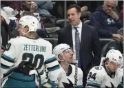  ?? DAVID ZALUBOWSKI — THE ASSOCIATED PRESS ?? San Jose Sharks head coach David Quinn, back, confers with players in the second period of a game against the Colorado Avalanche earlier this month in Denver.