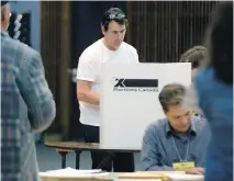  ?? PHIL CARPENTER/MONTREAL GAZETTE ?? Parti Québécois Leader Pierre Karl Péladeau, centre, votes in Outremont on Monday, during the last day of advance polling for Oct. 19 federal election.