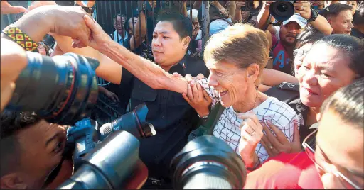  ?? MIGUEL DE GUZMAN ?? Australian missionary Sister Patricia Fox is welcomed by human rights activists as she is escorted by immigratio­n officers following her release from the Bureau of Immigratio­n compound in Manila yesterday.