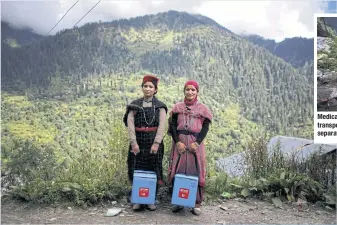  ?? ?? Nirma Devi and Phula Devi hold boxes containing Covishield vaccines in Kullu district in the Himalayan state of Himachal Pradesh, India.