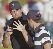  ?? AP PHOTO ?? BUMP UP IN COMPETITIO­N: Phil Mickelson celebrates with teammate Kevin Kisner during their Presidents Cup match yesterday in Jersey City, N.J.