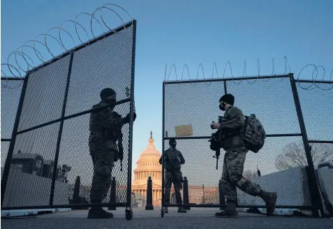  ?? CAROLYN KASTER/AP ?? National Guard soldiers open a gate of the perimeter fence around the U.S. Capitol this month in Washington. Security fencing is set to be removed from the Capitol, but metal detectors remain stationed outside the House chamber.