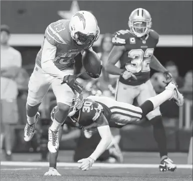  ?? TOM PENNINGTON / AGENCE FRANCE-PRESSE MOTOR RACING ?? Keenan Allen of the Los Angeles Chargers evades a tackle by Anthony Brown of the Dallas Cowboys en route to a touchdown during Thursday’s NFL game at AT&T Stadium in Arlington, Texas.