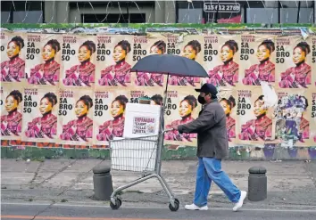  ?? ?? Un vendedor de empanadas, frente a propaganda de Francia Márquez, compañera de fórmula del candidato presidenci­al Gustavo Petro, de la coalición Pacto Histórico, en Bogotá.