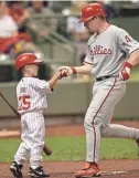  ?? JOURNAL SENTINEL FILES ?? A young Varsho greets the Phillies’ Randy Wolf in 2002. Varsho’s father was a coach for the Phillies at the time.