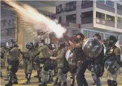  ??  ?? 0 Riot police fire tear gas at protesters in Kowloon yesterday