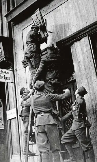  ?? FOTO ARCHIV K. STRAKY ?? Září 1938. Armádní asistenční oddíl snímá znak Sudetoněme­cké strany z budovy sekretariá­tu po zákazu strany. Bartíkova kontrarozv­ědka měla poznatky, že strana působí jako protistátn­í agentura nacistické­ho Německa.