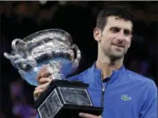  ?? AARON FAVILA — THE ASSOCIATED PRESS ?? Serbia’s Novak Djokovic holds his trophy after defeating Spain’s Rafael Nadal in the men’s singles final at the Australian Open tennis championsh­ips in Melbourne, Australia, Sunday.