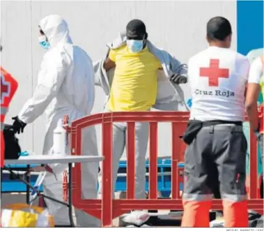  ?? MIGUEL BARRETO / EFE ?? Un inmigrante de Malí se pone una sudadera mientras es atendido ayer en el puerto de Los Cristianos (Tenerife).