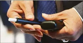  ?? Tyler Sizemore / Hearst Connecticu­t Media ?? Philip Morris Internatio­nal Americas Region President Deepak Mishra shows the company's smoke-free heated tobacco product IQOS while touring the future headquarte­rs of Philip Morris Internatio­nal in Stamford, Nov. 8, 2021.