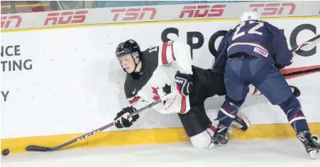  ?? JEFF BASSETT, THE CANADIAN PRESS ?? Canada White’s MacKenzie Entwistle tries to make a pass while being checked by Team USA’s Sasha Chmelevski during the first period of their exhibition game at the Sandman Centre in Kamloops on Tuesday.