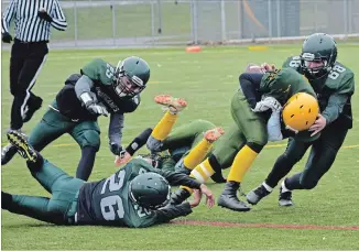  ?? SUBMITTED PHOTO ?? The Holy Cross Hurricanes try to contain a Centennial Chargers runner during the COSSA AA senior football championsh­ip in Belleville on Thursday afternoon. Belleville won 31-0.