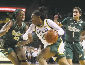  ?? Rod Aydelotte / Associated Press ?? Baylor guard Juicy Landrum, center, drives between South Florida center Shae Leverett, left, and South Florida guard Maria Alvarez, right, in the second half during a game in November.