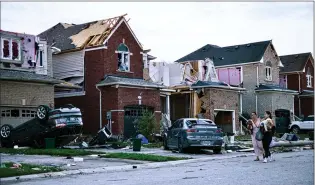 ?? CANADIAN PRESS PHOTO ?? Residents leave their homes after a tornado tore through Barrie, Ont., on Thursday afternoon. Several people were injured and a number of homes were damaged or destroyed but no fatalities resulted from the EF-2 twister.