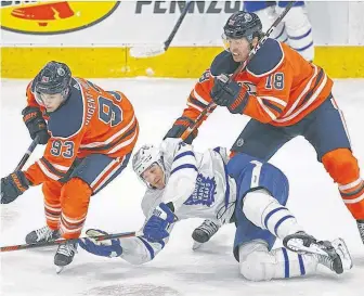  ?? POSTMEDIA ?? Toronto Maple Leafs Zach Hyman (middle) is checked by Edmonton Oilers Ryan Nugent-hopkins (left) and James Neal (right) during first period NHL game action in Edmonton on Saturday.