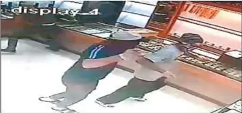  ?? Courtesy: Dubai Police ?? CCTV footage of the robbery in a jewellery shop at Internatio­nal City on Wednesday shows the masked men carrying out the heist with a large butcher knife and pepper spray.