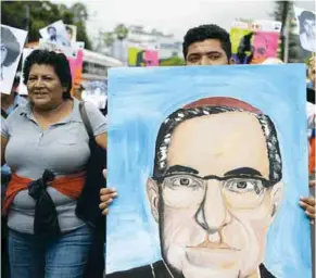  ??  ?? VENERADO.Campesinos marchan en El Salvador con una imagen de Monseñor Óscar Romero, a quien le atribuyen diversos m ilagros.