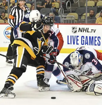  ?? Peter Diana/Post-Gazette ?? said. “That’s what we like about what he brings to the top-six if we so choose to do that.” Brandon Tanev battles for a loose puck with Blue Jackets defenseman Gabriel Carlsson Thursday at PPG Paints Arena. “He’s got a physical edge to him,” Penguins coach Mike Sullivan said.