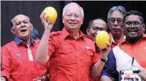  ??  ?? Najib shares a light moment with Umno officials yesterday after he was presented with two melons during the Umno divisional and wing meetings in Pekan yesterday.