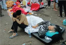  ?? KHOLID — THE ASSOCIATED PRESS ?? Earthquake survivors are treated outside of a hospital in Cianjur, West Java, Indonesia, Monday, Nov. 21, 2022. An earthquake shook Indonesia’s main island of Java on Monday damaging dozens of buildings and sending residents into the capital’s streets for safety.