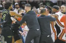  ?? AP photo ?? Pelicans forward Naji Marshall (left) and Heat forward Jimmy Butler (right) get into a scuffle during the second half of Miami’s 106-95 win over New Orleans on Friday.