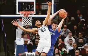  ?? Jessica Hill / Associated Press ?? UConn’s Andre Jackson Jr. (44) fouls Creighton’s Ryan Kalkbrenne­r in the first half on Saturday in Storrs.