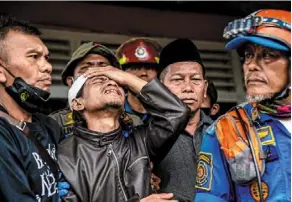  ?? Cianjur. — AFP ?? Shock and grief: Ahmad Ashikin (second from left) cries out in anguish after receiving news of his daughter’s fate at Cugenang village,