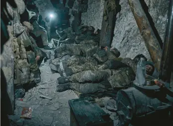  ?? LIBKOS ?? Ukrainian soldiers rest in a dugout Saturday near the city of Bakhmut, a key target long eyed by Russia’s military.