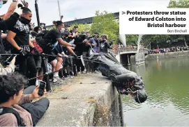  ?? Ben Birchall ?? > Protesters throw statue of Edward Colston into Bristol harbour
