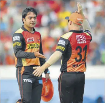  ?? AFP ?? Sunrisers Hyderabad captain David Warner (right) congratula­tes Rashid Khan on taking three wickets against Gujarat Lions in Hyderabad on Sunday. Sunrisers won by nine wickets.