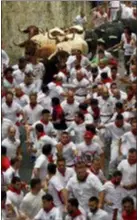  ??  ?? Revellers run next to fighting bulls during the running of the bulls at the San Fermin Festival, in Pamplona, northern Spain, Sunday. Revellers from around the world flock to Pamplona every year to take part in the eight days of the running of the bulls.