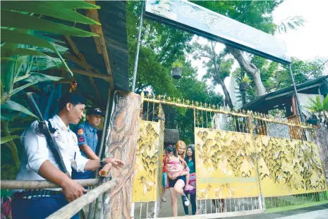  ?? (SUNSTAR FOTO\AMPER CAMPAñA) ?? WATCH OUT. A security guard and a police officer man the gate of the Cebu City Zoo in Barangay Kalunasan, Cebu City.