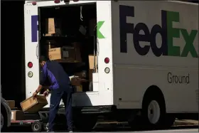  ??  ?? A FedEx Corp. worker unloads a truck in downtown Dallas in May. (Bloomberg News/Cooper Neill)