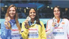  ?? — AFP photo ?? Gold medalist Brazil’s Etiene Medeiros (left), silver medalist China’s Fu Yuanhui (right) and bronze medalist Belarus’ Aliaksandr­a Herasimeni­a celebrate on the podium of the women’s 50m backstroke event during the swimming competitio­n at the 2017 FINA World Championsh­ips.