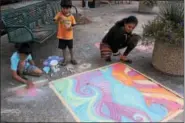  ?? MICHILEA PATTERSON — DIGITAL FIRST MEDIA ?? A family makes a colorful chalk dedication to the victims of Hurricane Harvey which includes the words rise, renew and hope. There was a sidewalk chalk festival at Smith Family Plaza on Thursday as part of the “Almost Friday” event of the weekly...