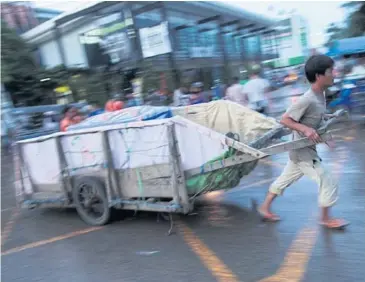  ?? PATIPAT JANTHONG ?? A Cambodian worker transports goods from a Thai border market in Sa Kaeo to Cambodia. The Asean Economic Community is nowhere near the definition of ‘a single market’.