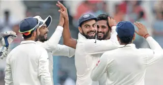  ?? – AFP ?? FIVE FOR: India’s Bhuvneshwa­r Kumar, second right, celebrates with his teammates after claiming one of his five victims during the second day of their second Test match against New Zealand at the Eden Gardens in Kolkata on Saturday.