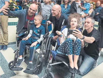  ?? TIJANA MARTIN/THE CANADIAN PRESS ?? Former Toronto Maple Leafs captain Mats Sundin, centre, counts down to his banner reveal as John Zianis, left, Peter Zianis, 8, Ariana Ruffolo, 15, and Ralph Ruffolo watch as part of the Toronto Maple Leafs Banner Tour at Sick Kids hospital on Monday.