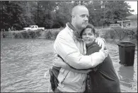  ?? AP/Austin American-Statesman/JAY JANNER ?? David White hugs his neighbor Sherry Blincoe after she was rescued by boat from her flooded home Wednesday in Beaumont, Texas.