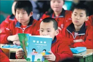  ??  ?? A boy consults the controvers­ial sex education textbook.