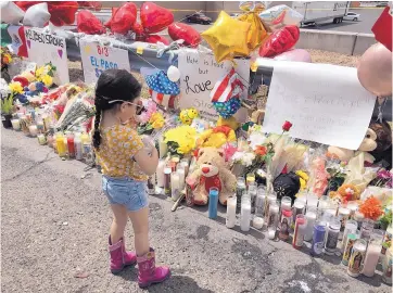  ?? ANGELA KOCHERGA/JOURNAL ?? A young girl stands in front of a makeshift memorial outside an El Paso Walmart that was the scene of a shooting that killed 22 people and injured 26. Countless parents have taken their children to the memorial to pay their respects and talk about the attack.