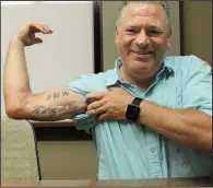  ?? Arkansas Democrat-Gazette/SEAN CLANCY ?? Dan Myers lost part of his right bicep and tricep to cancer. His tattoo reads: “The strong will rise” and includes the date of his diagnosis — May 21, 1999.