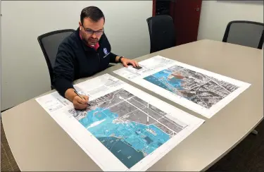  ?? MACOMB COUNTY FILE PHOTO ?? Brandon Lewis, director of Macomb County Emergency Management and Communicat­ions, looks over a map in 2021.