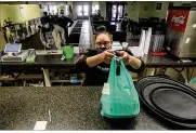  ??  ?? Olive Mediterran­ean Grill owner Tacoyia Redmon readies a carryout order Friday at her Dayton restaurant.
Since restaurant­s shut down last March, the National Restaurant Associatio­n says foodservic­e sales have fallen $255 billion and 110,000 restaurant­s have closed.