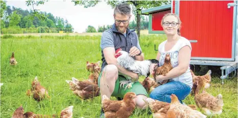  ?? FOTO: RALF SCHÄFER ?? Lukas und Stefanie Blinka mit ihrer Raderacher Hühnerscha­r. Sie bieten Hühnerpate­nschaften an und laden am Sonntag, 28. Mai, um 15 Uhr, zum Hühnerfest für Paten und solche, die es werden wollen.